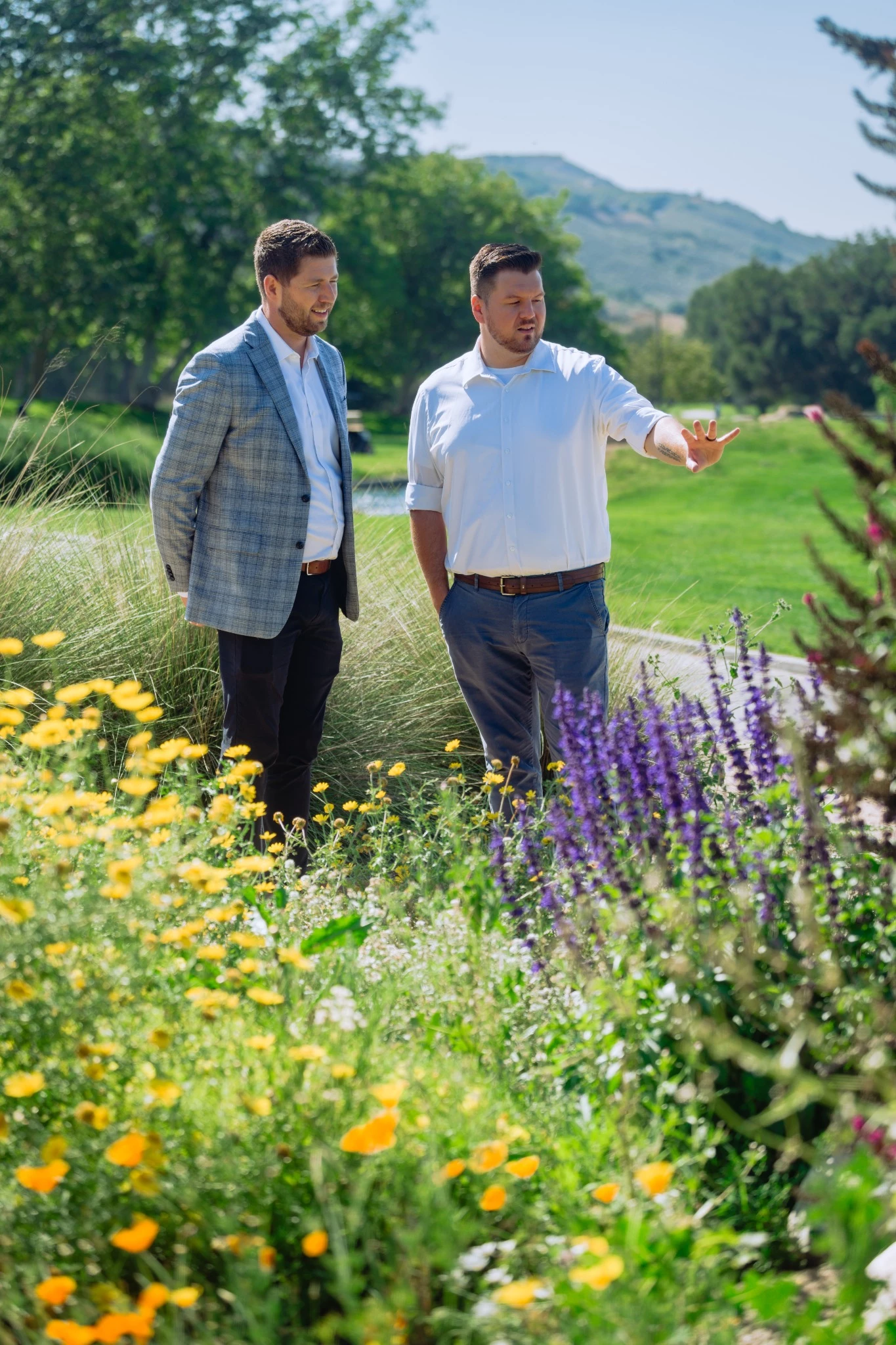 two men standing in a field of flowers