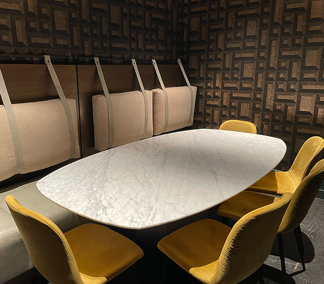 round marble table with yellow chairs around it