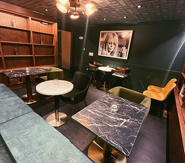 various tables in black and white marble with yellow and blue seating