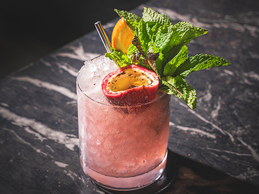 a glass with a drink and fruit in it