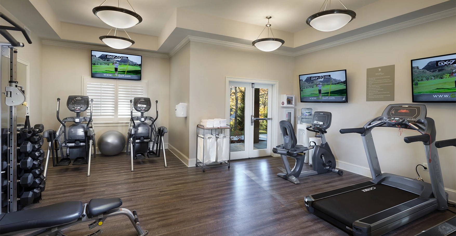 a gym with exercise equipment and a television