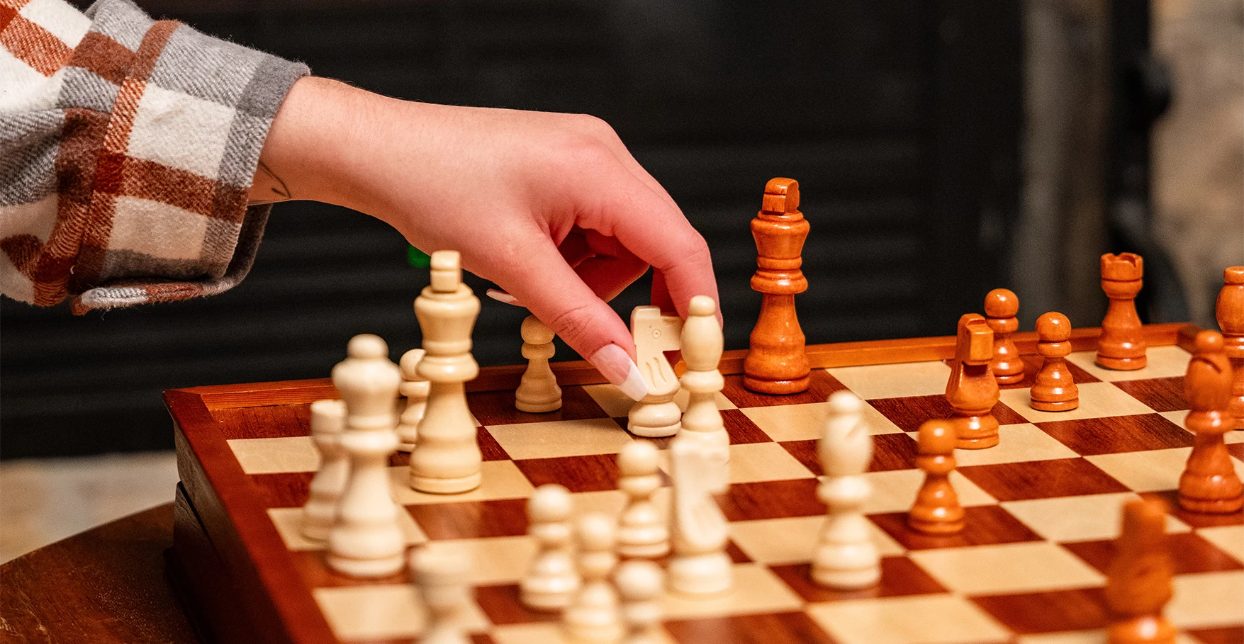 a hand playing chess with a chess board