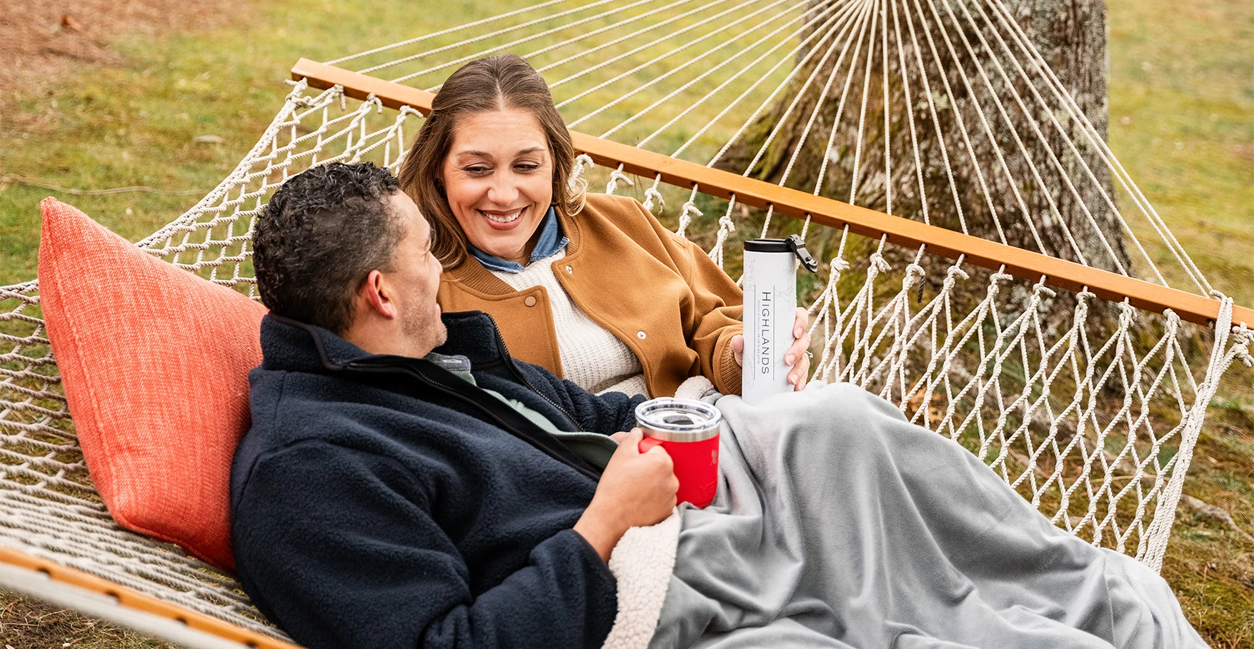 a man and woman sitting in a hammock
