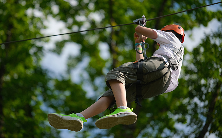 a boy in a helmet on a zip line