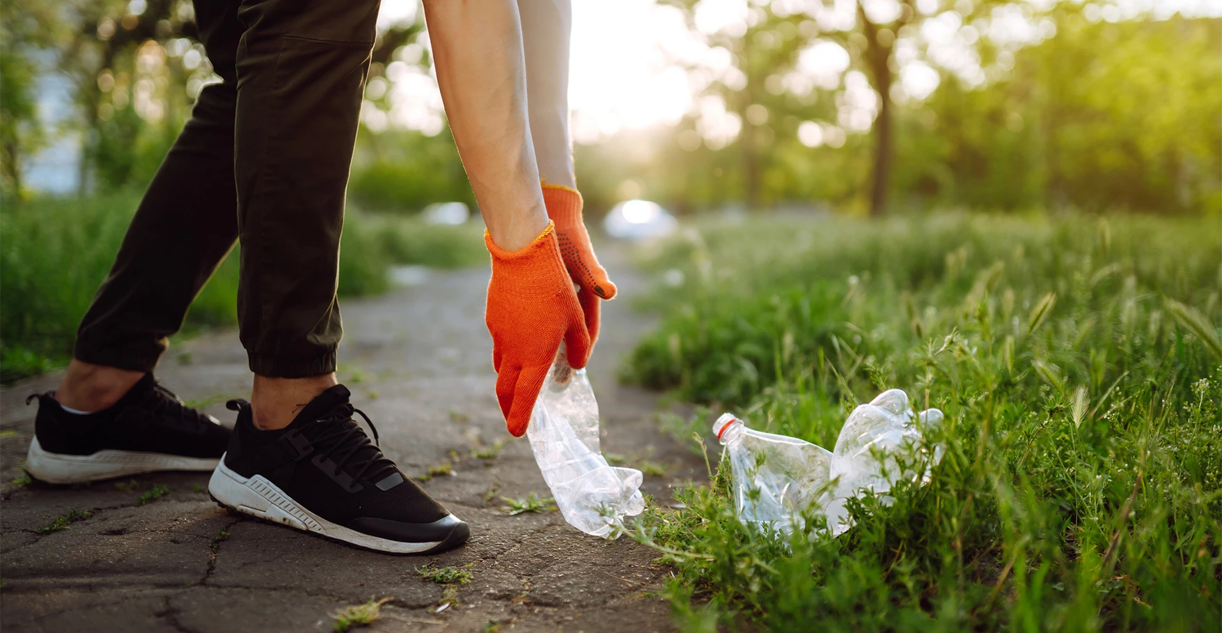 a person picking up a plastic bottle