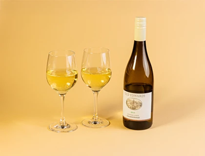 a bottle of wine next to two wine glasses
