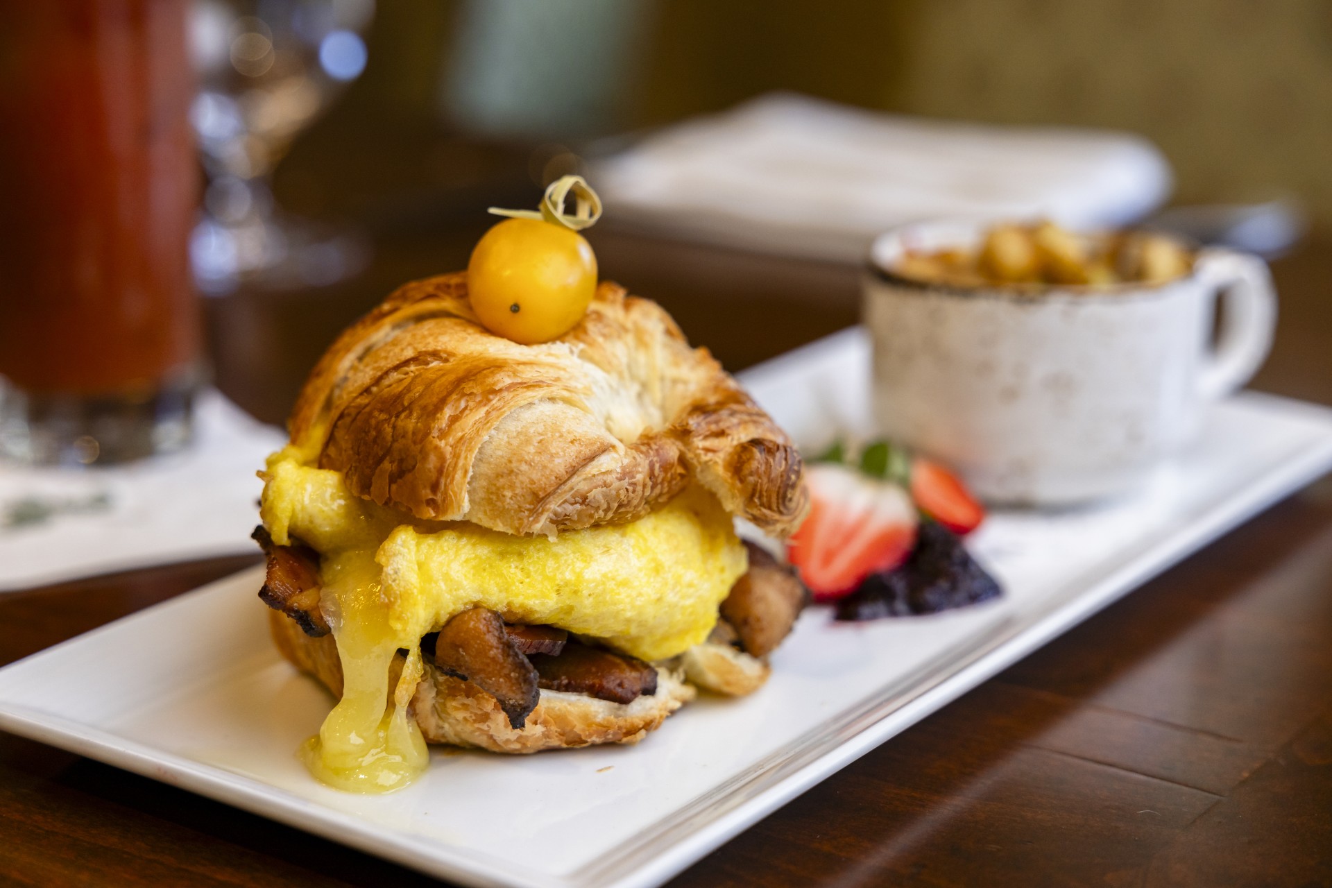 a croissant sandwich with egg and cheese on top