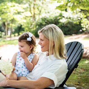 a woman and a baby sitting on a bench