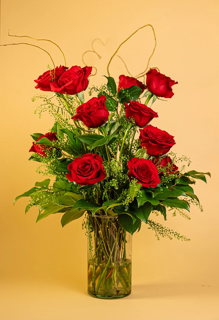 a bouquet of red roses in a glass vase