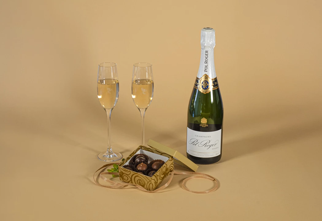 a bottle of champagne next to two glasses of chocolates