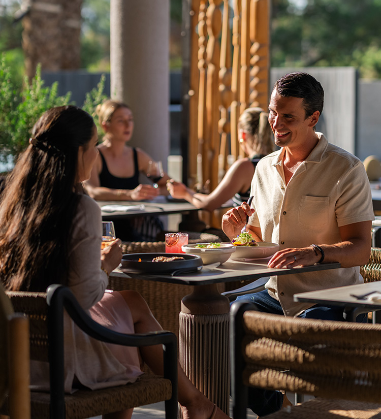 a man and woman sitting at a table with food