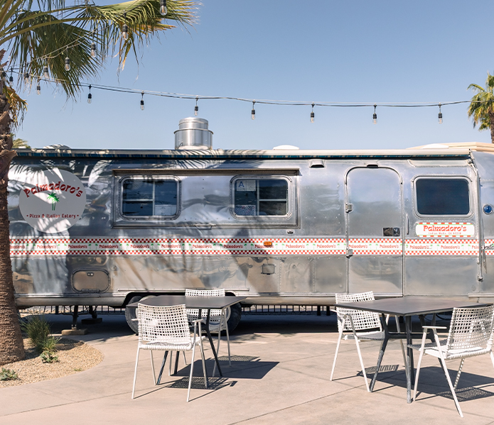 a silver trailer with chairs and tables