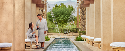 a man and woman standing next to a fountain