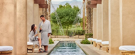a man and woman standing next to a fountain