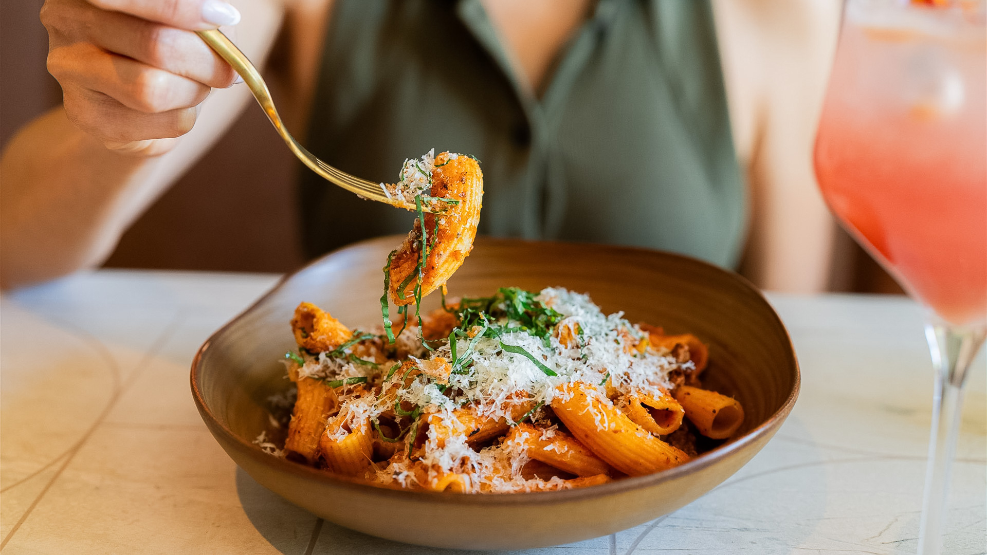 a person holding a fork over pasta