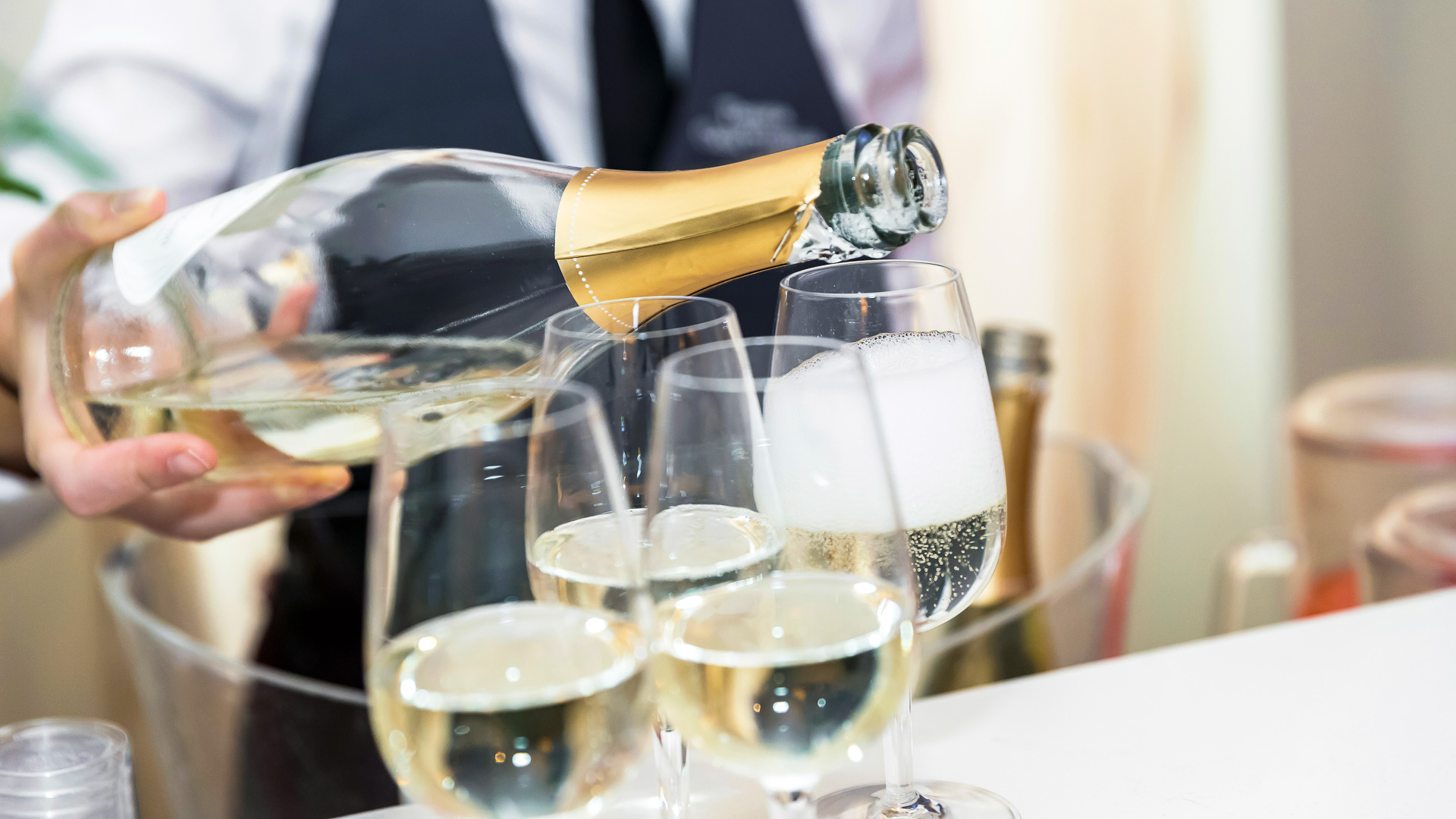 a person pouring champagne into glasses