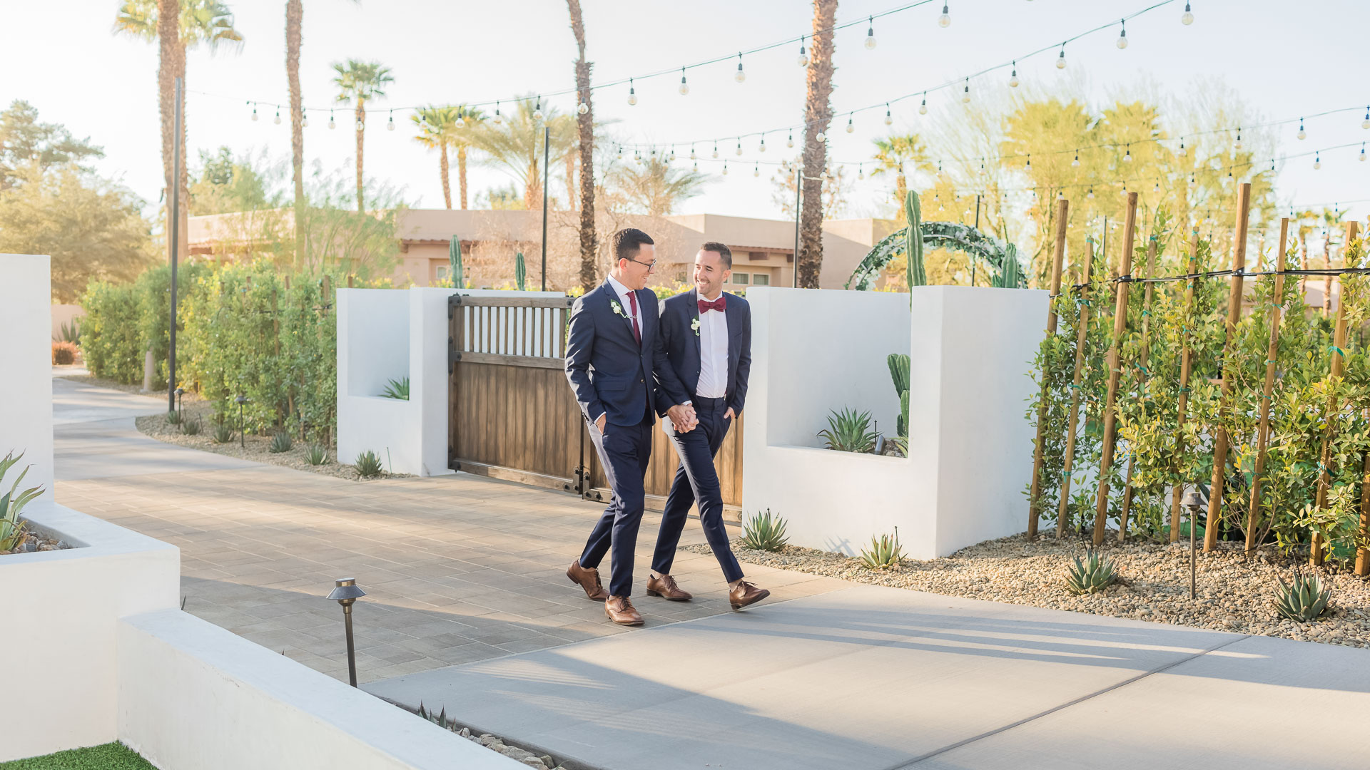 two men in suits walking on a sidewalk