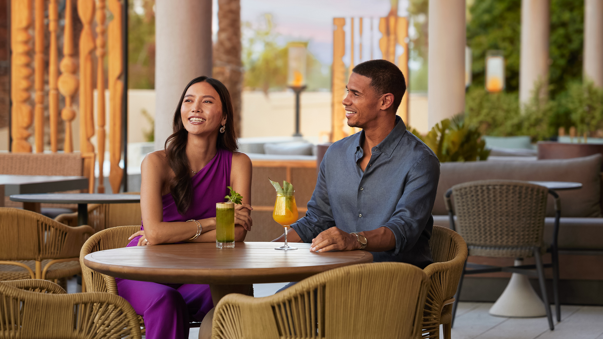 a man and woman sitting at a table with drinks