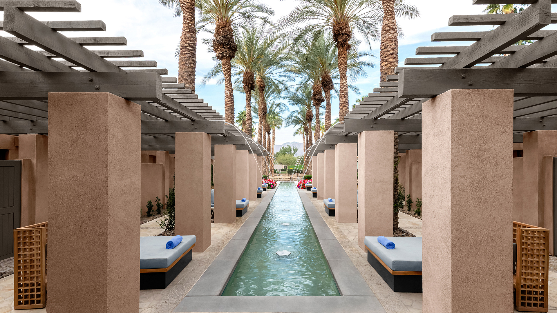 a pool with a water fountain and palm trees