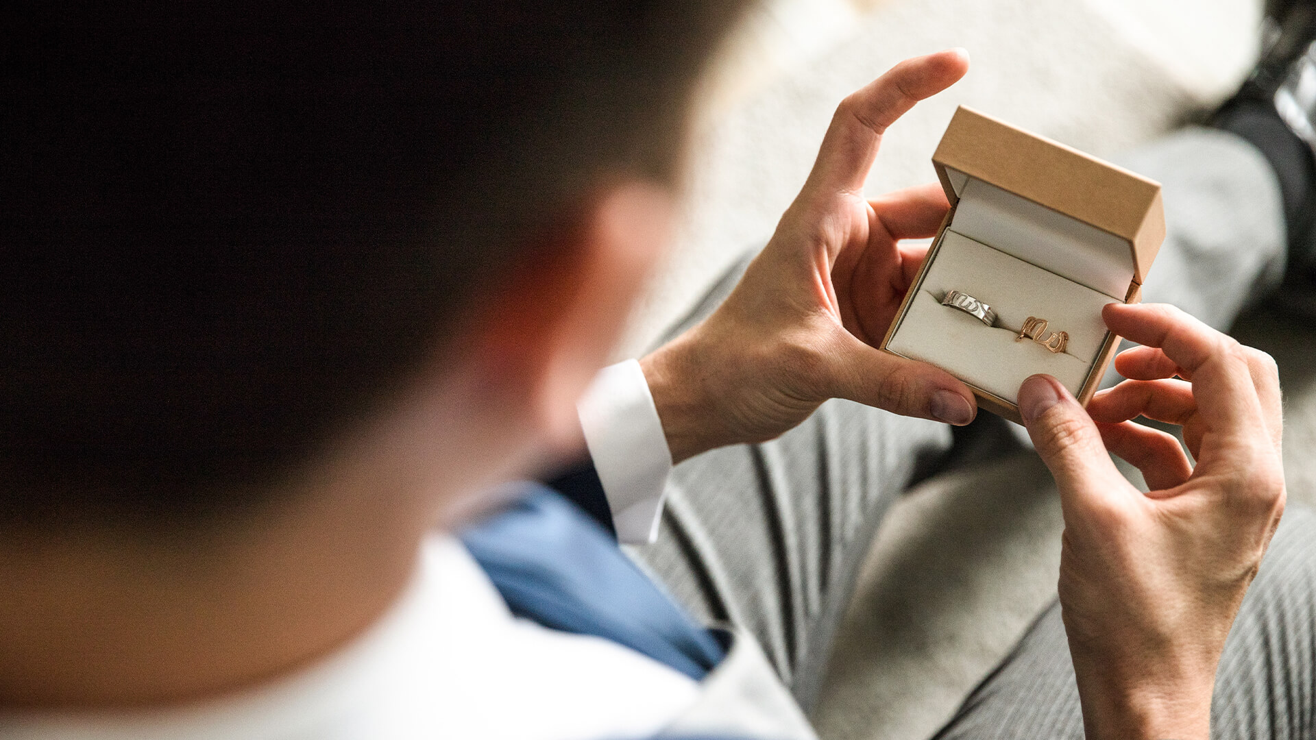 a man holding a ring in a box
