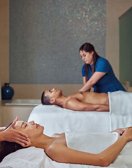 a man and woman lying on massage beds