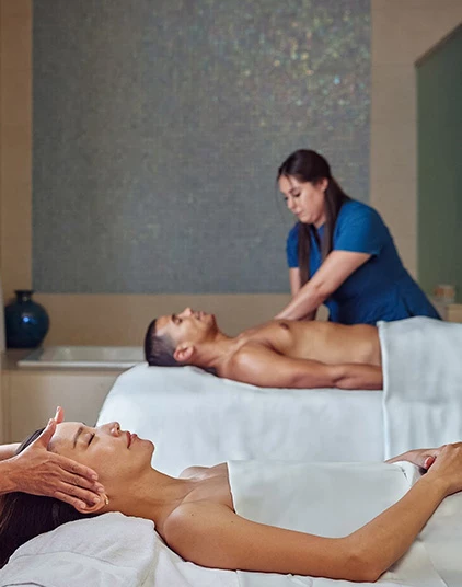 a man and woman lying on massage beds