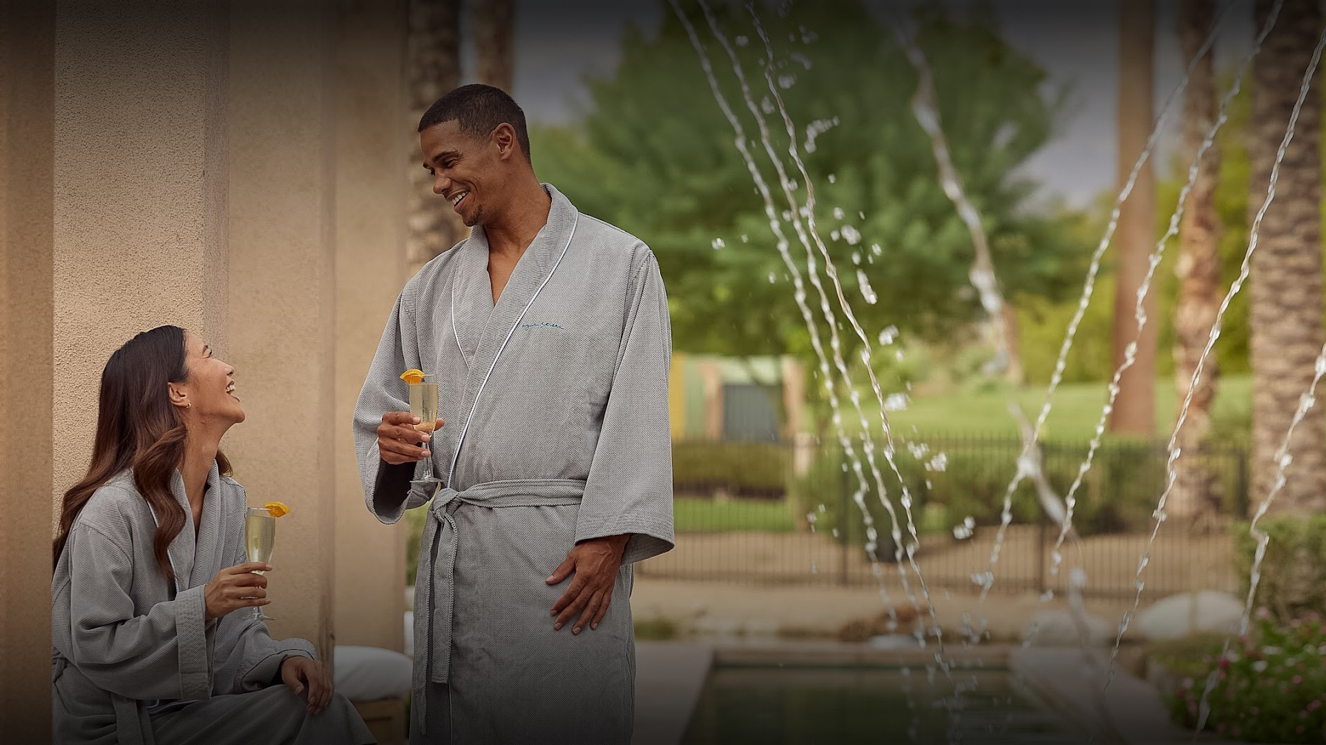 a man in a robe holding a drink