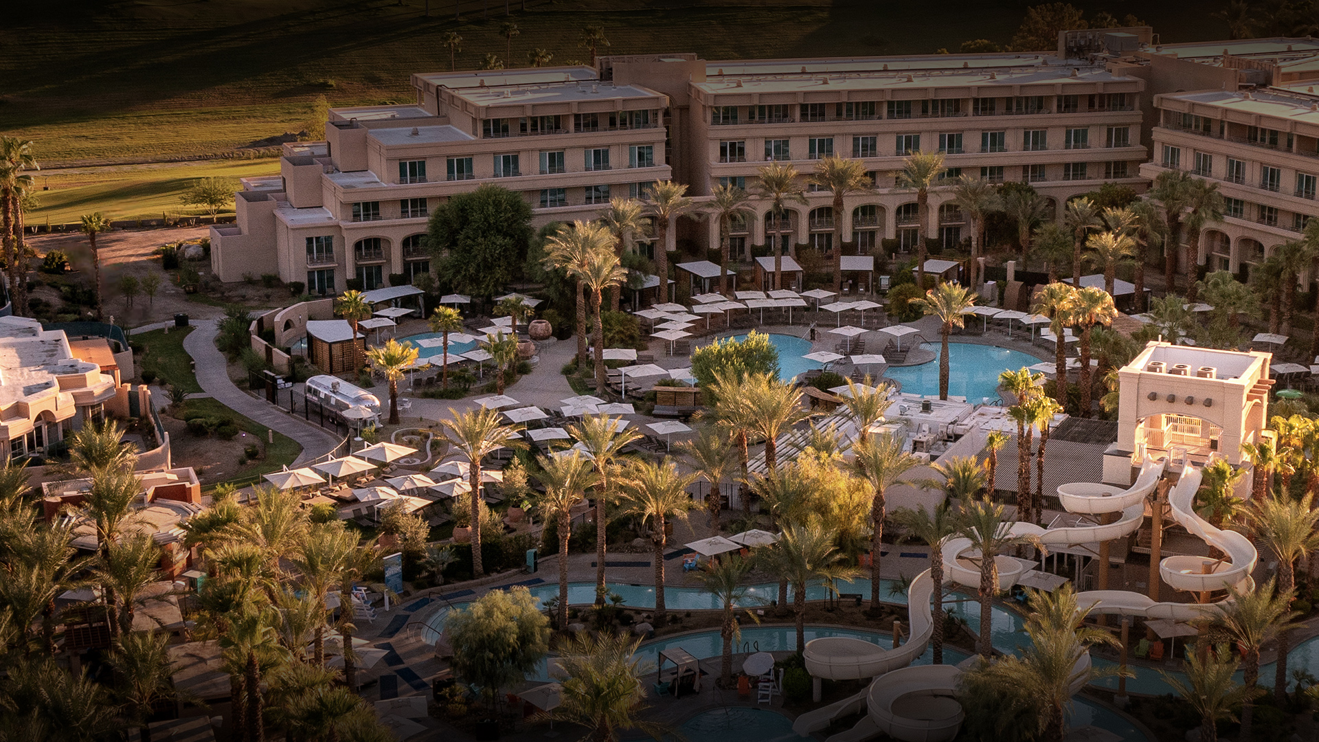 a swimming pool and a building with palm trees