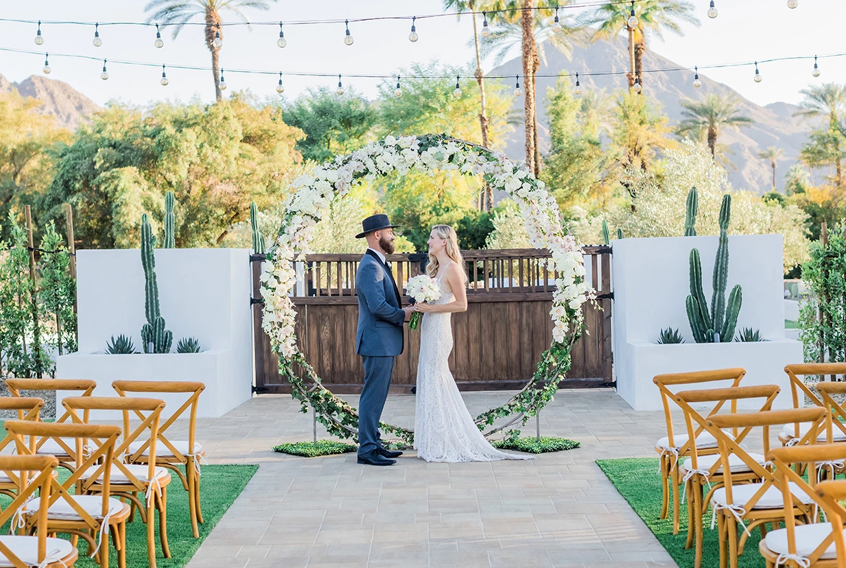 a man and woman standing in front of a circular arch