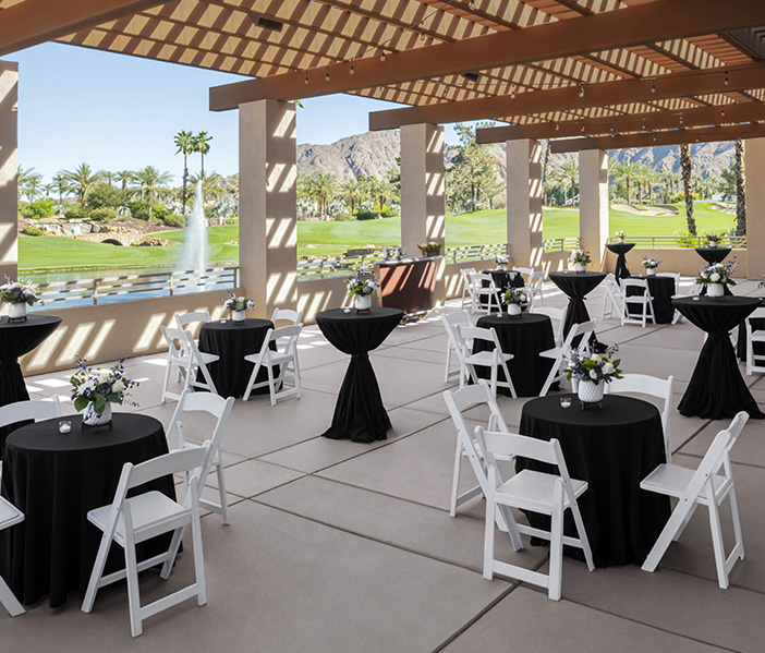 a group of tables and chairs with black cloths