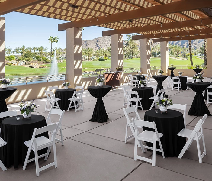 a group of tables and chairs with black cloths