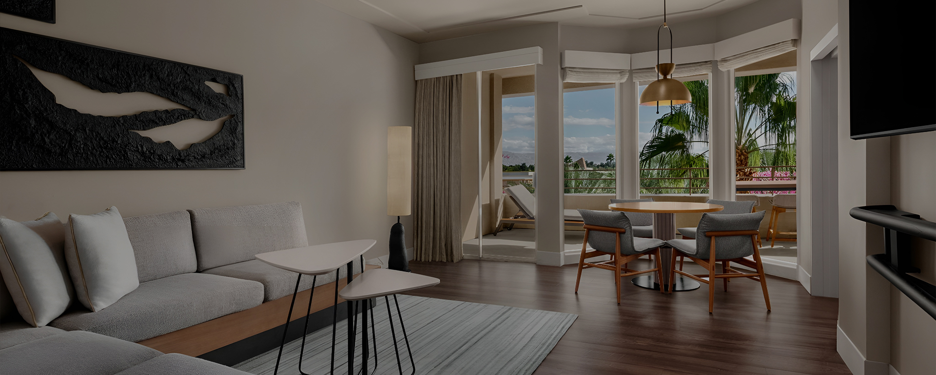 a room with a table and chairs and a deck with a view of the ocean