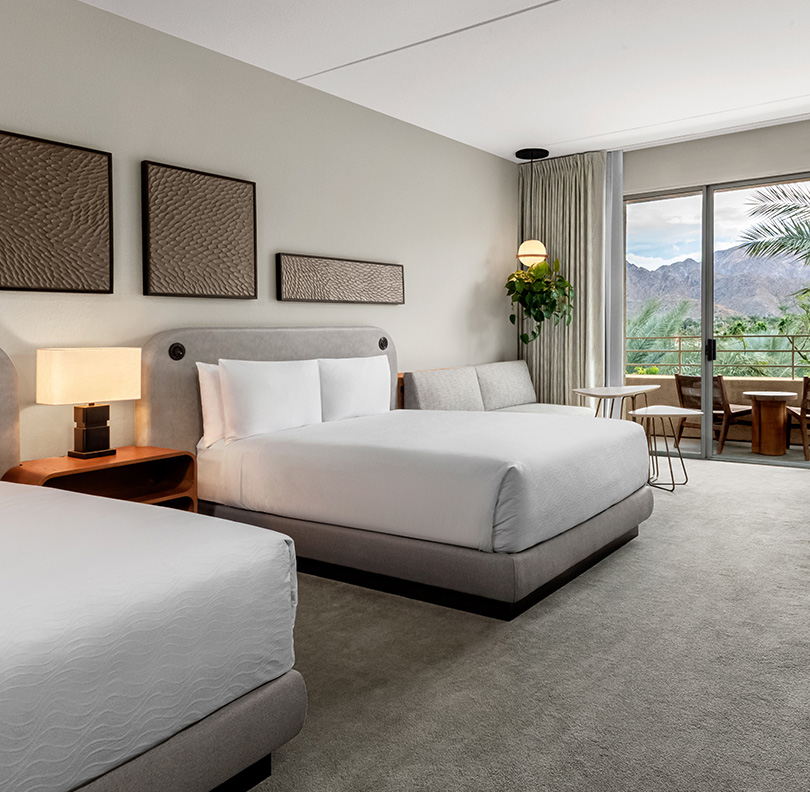 a hotel room with two beds and a balcony