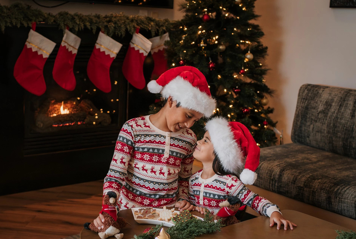 two children wearing santa hats and sitting at a table