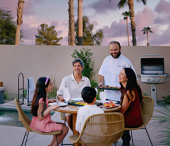 a group of people sitting around a table with food