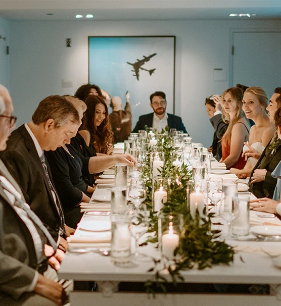 long wedding reception table with candles and greenery down the middle