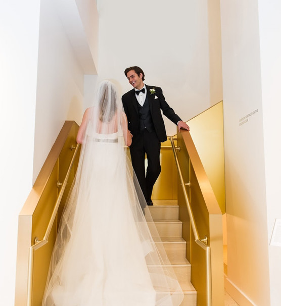 bride and groom walking up gold stairs