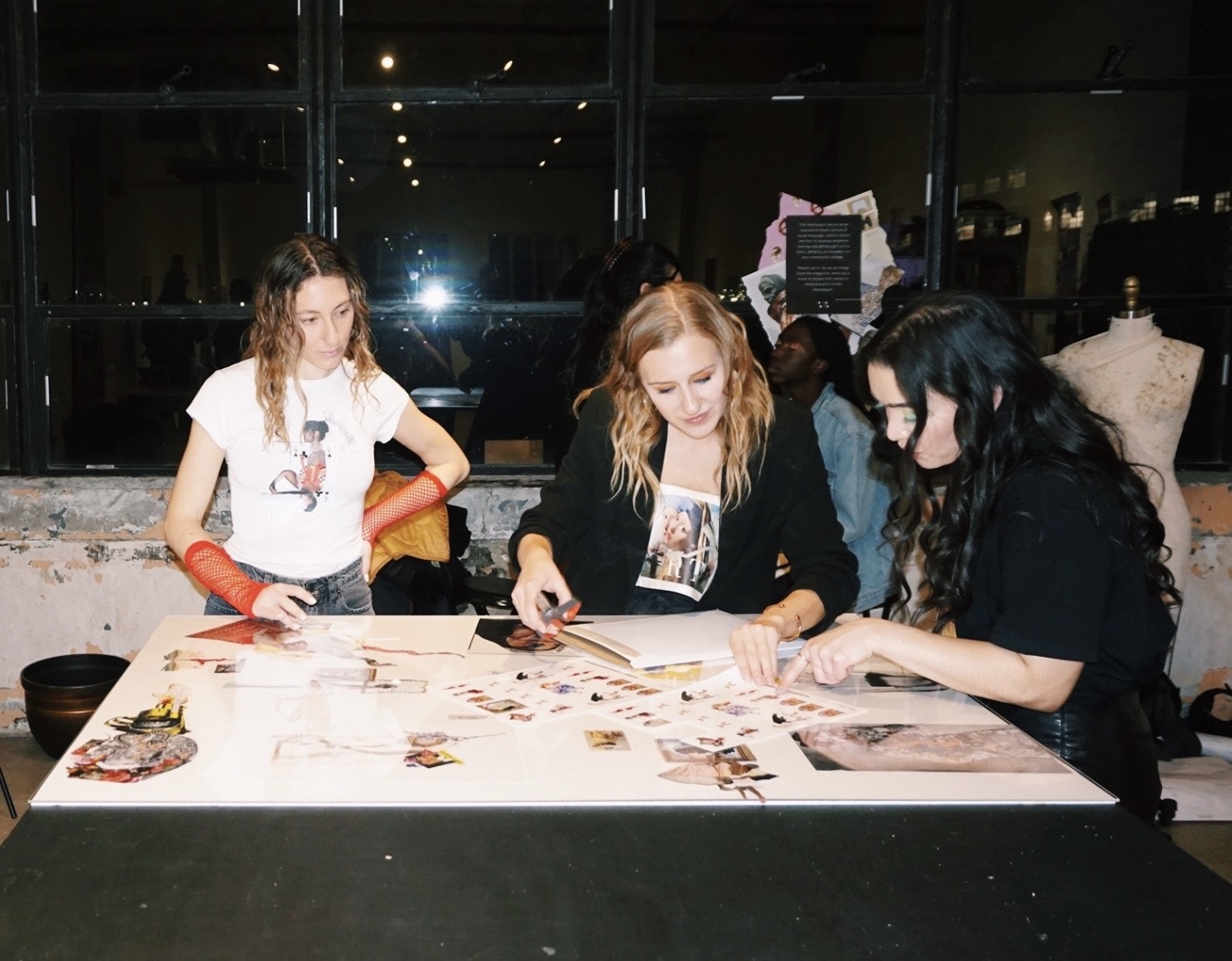a group of women sitting at a table looking at pictures