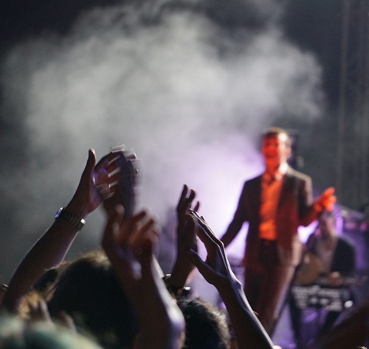 a crowd of people with their hands raised in the air