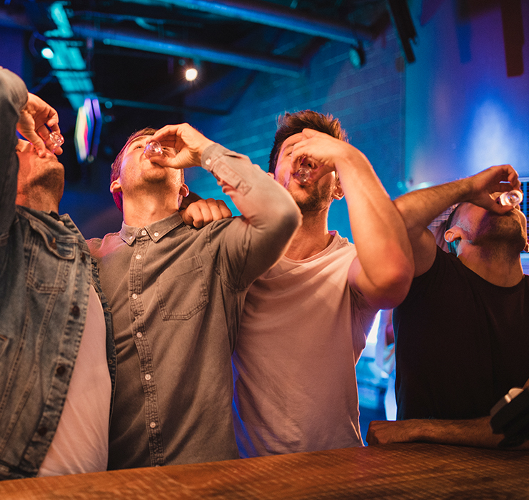 a group of men drinking from a glass