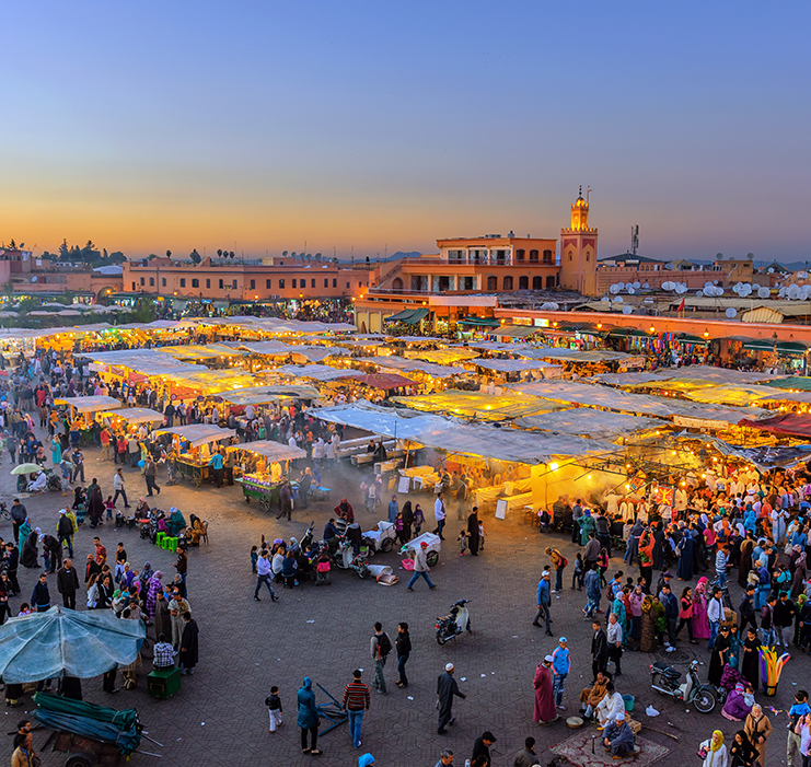 a large crowd of people in a square with tents and tents