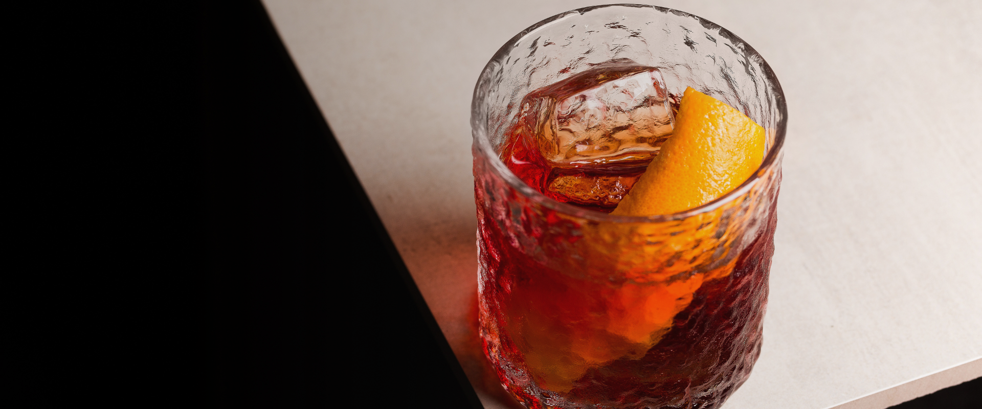 a glass with a drink and a slice of orange on top
