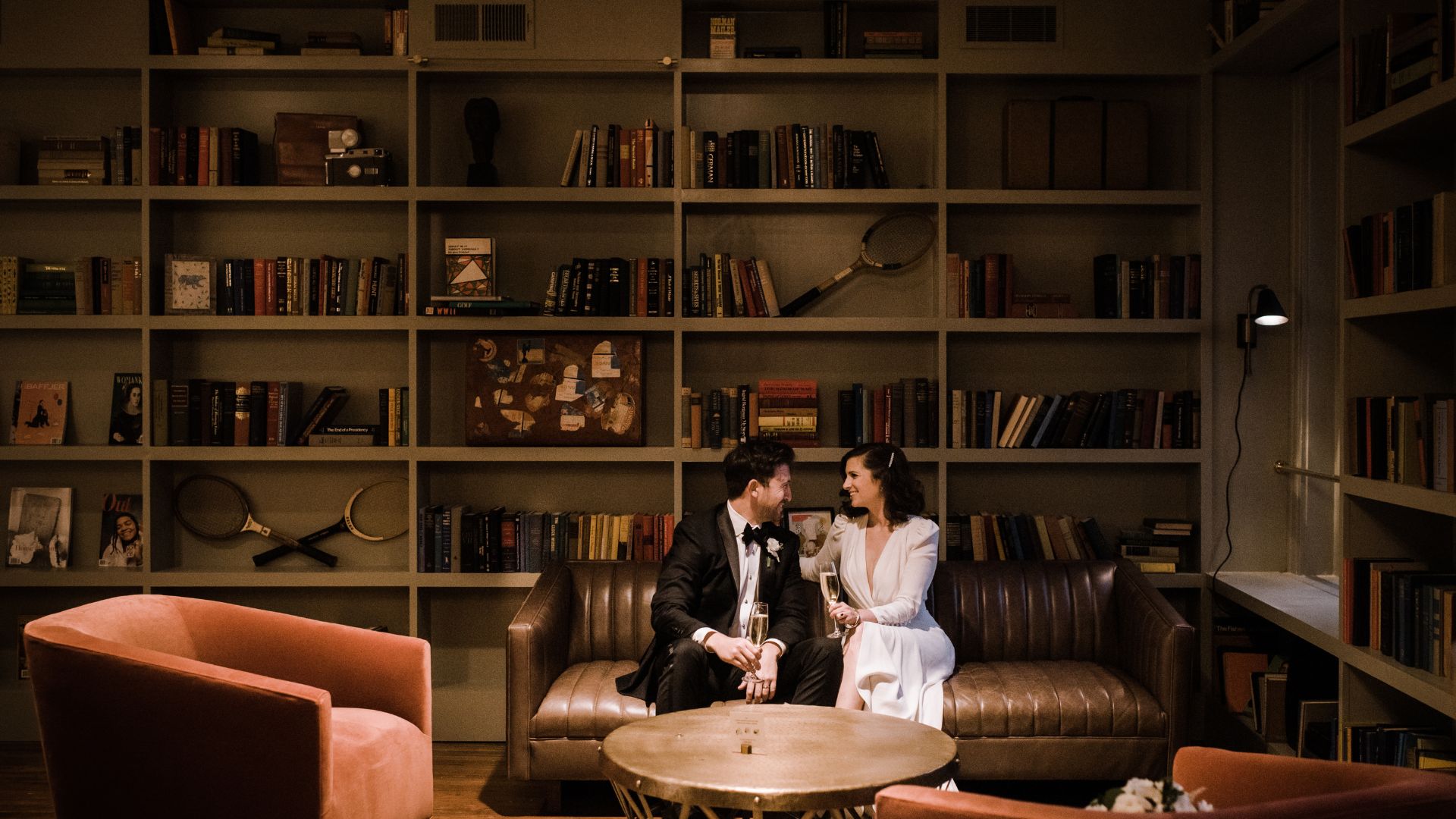 a man and woman sitting on a couch with wine glasses