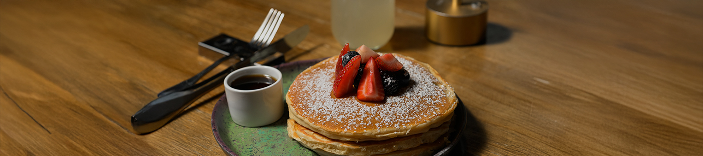 a stack of pancakes with strawberries and blueberries