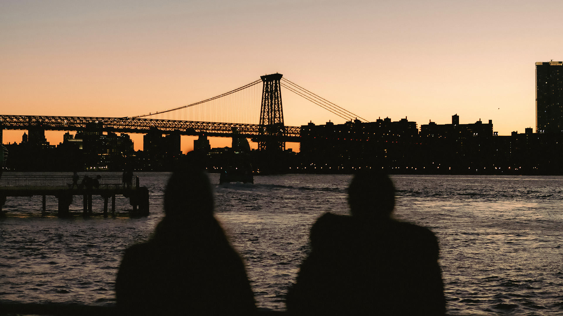 a silhouette of a bridge and a city