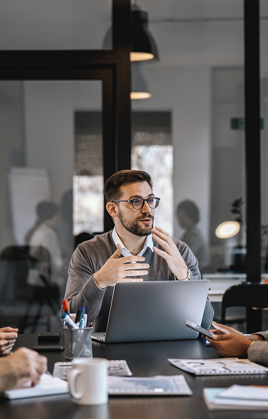 a man in glasses talking to a group of people