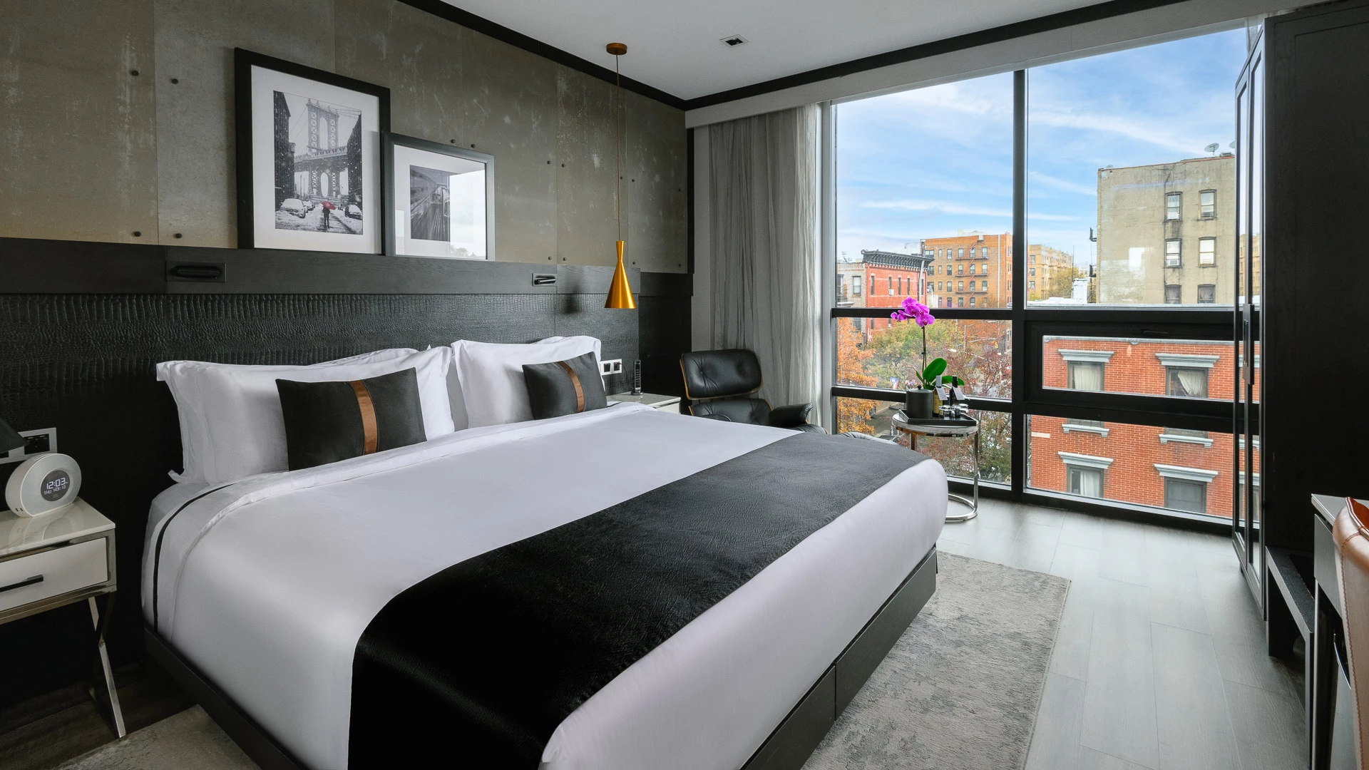 A modern hotel room with a large bed, window, and city view.