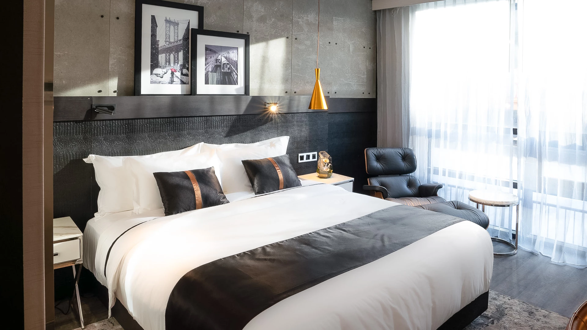 A hotel room with a large bed, chair, and window.