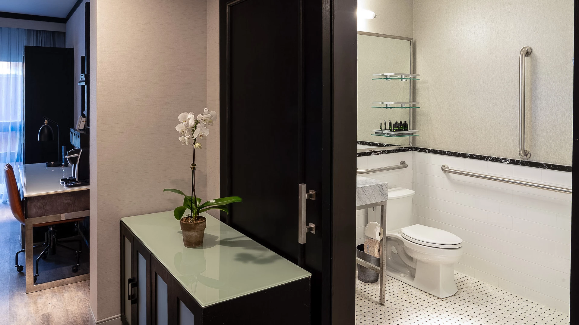 A bathroom with a toilet, sink, and mirror