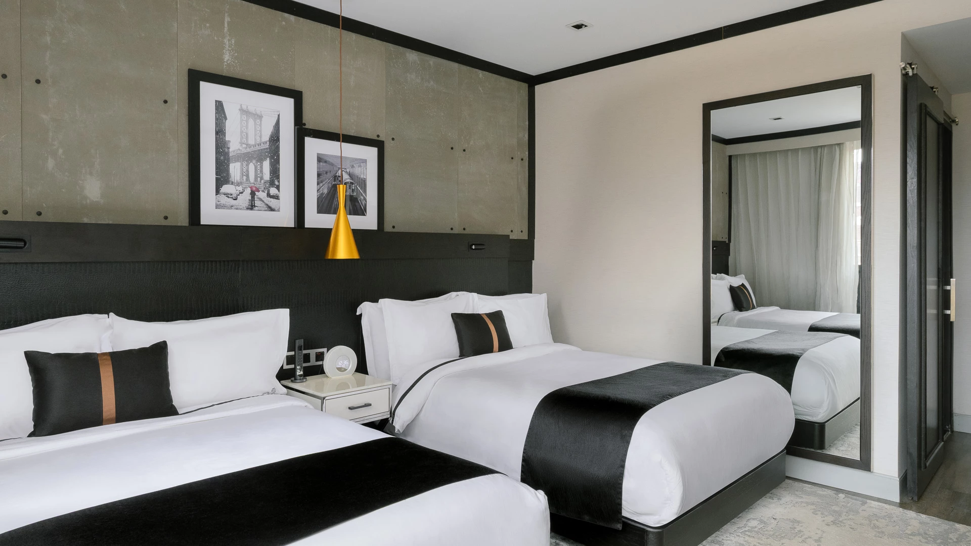 A hotel room with two beds, a nightstand, and artwork on the wall.
